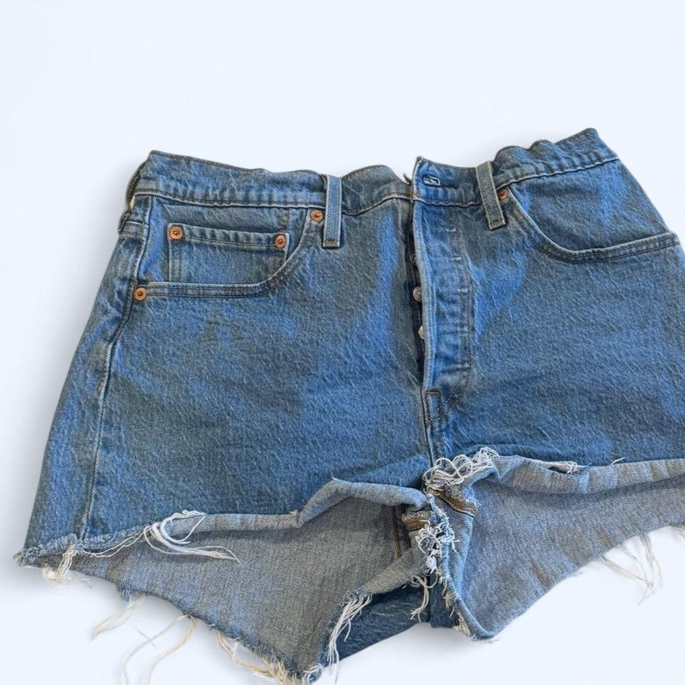 Levi's blue denim shorts with frayed hem and button fly. Size: 26"